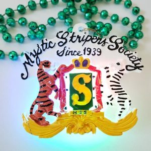 Over Seas custom shape LED medallion lit up on a green Mardi Gras strand